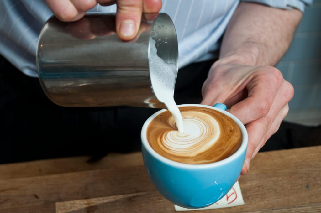 Pouring latte art with milk pitcher